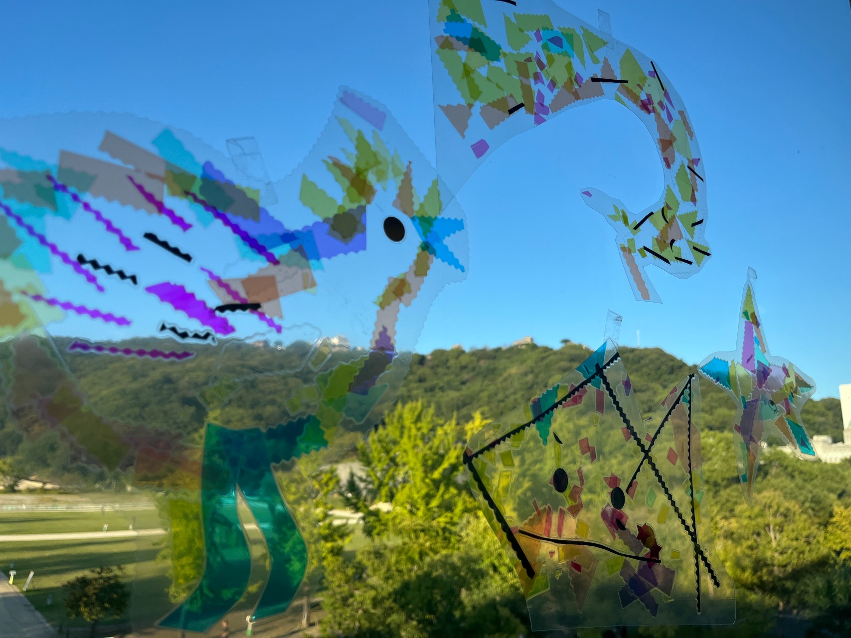 窓にセロハンで鳥の形をかたどったものを貼っている