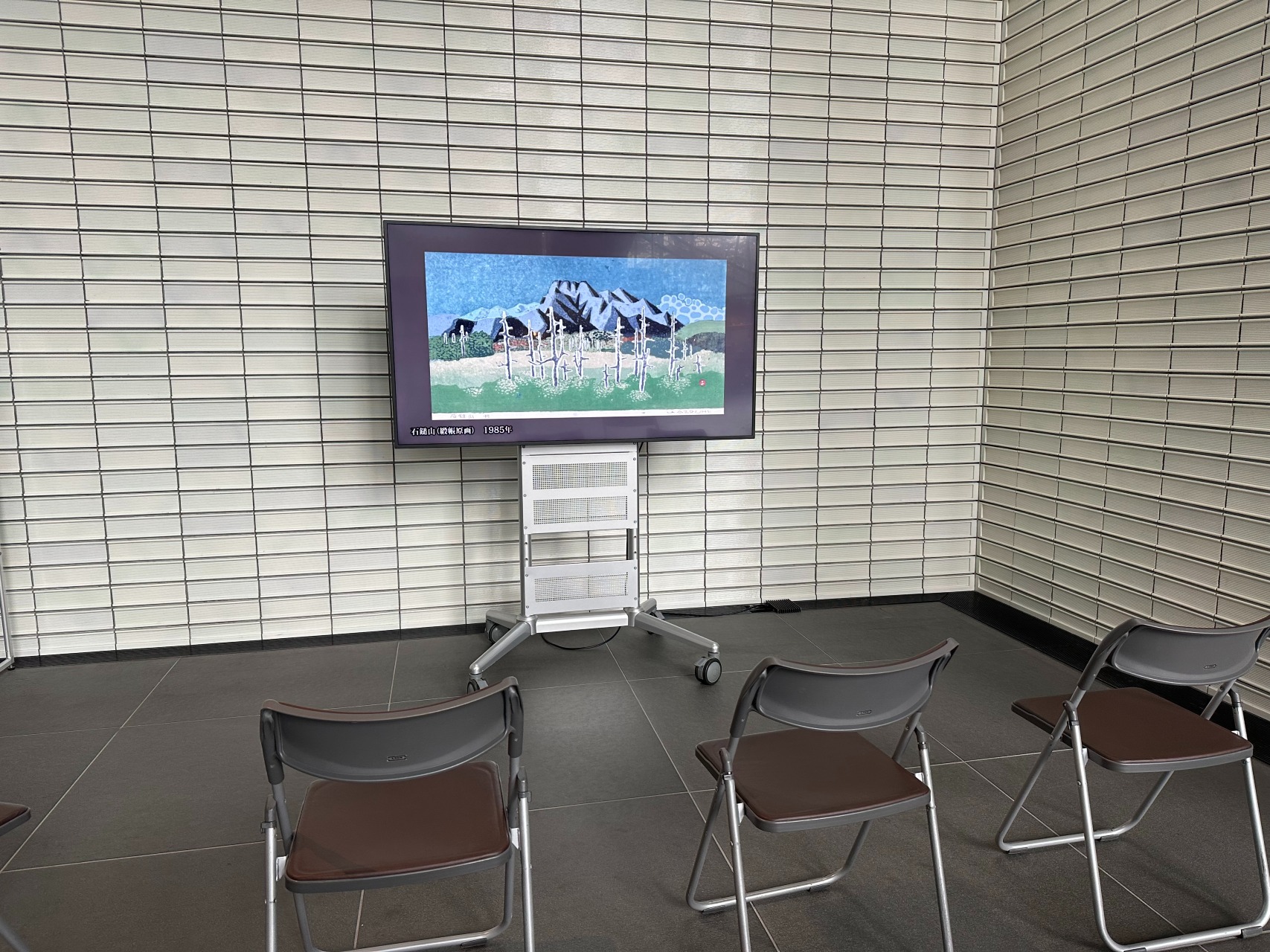 모니터 앞에 파이프 의자가 놓여 있습니다.