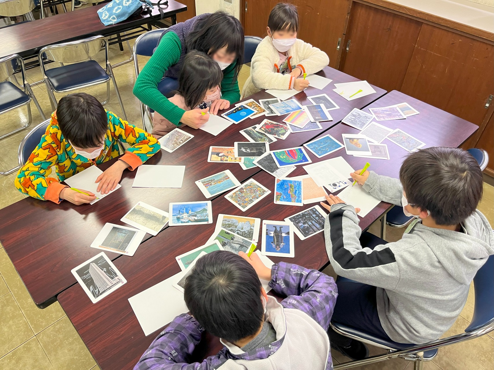 机に並べたアートカードを6人が囲んでゲームをしている様子