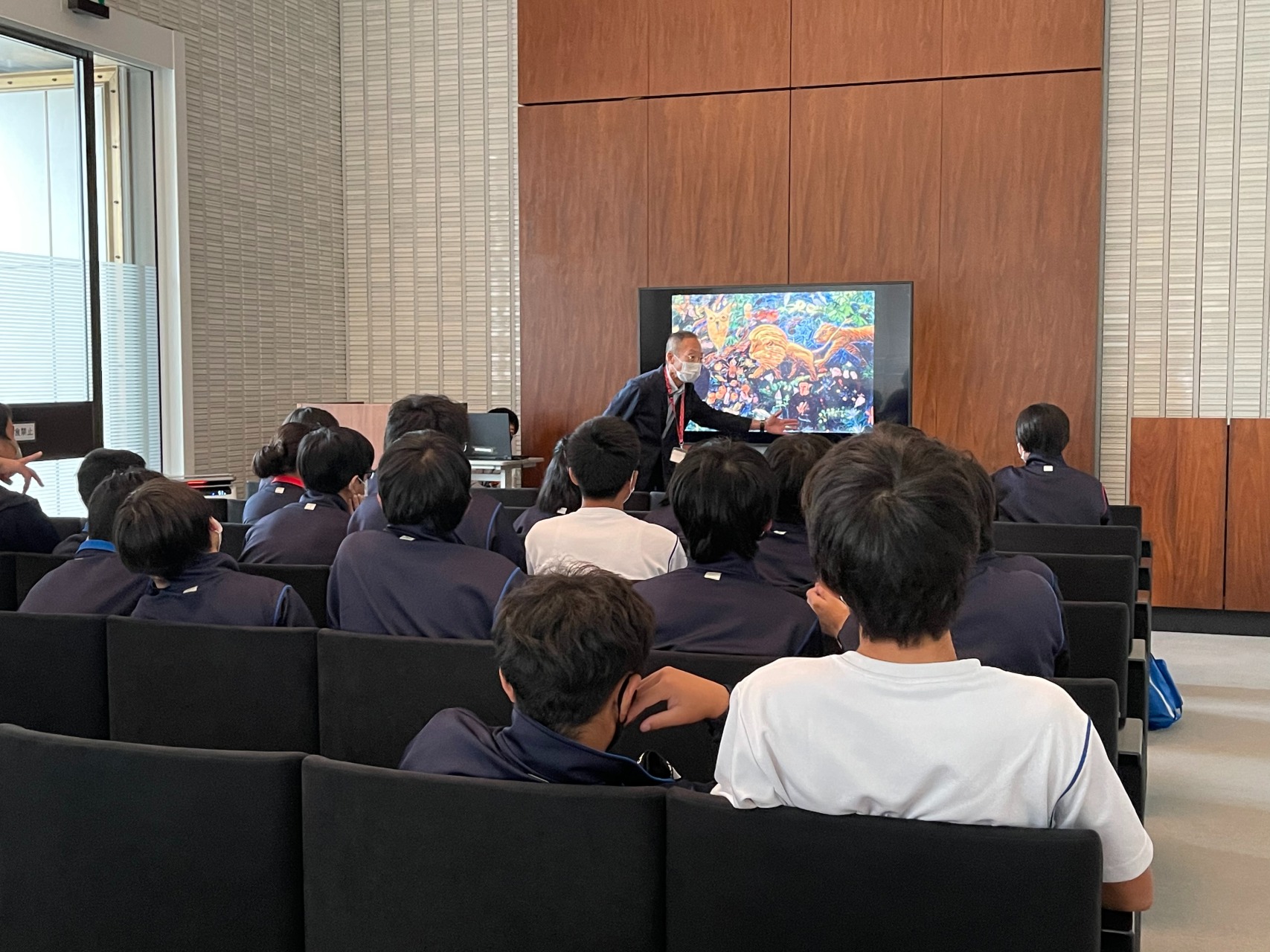 研修室でモニターの作品画像を前に対話型鑑賞を実施している様子